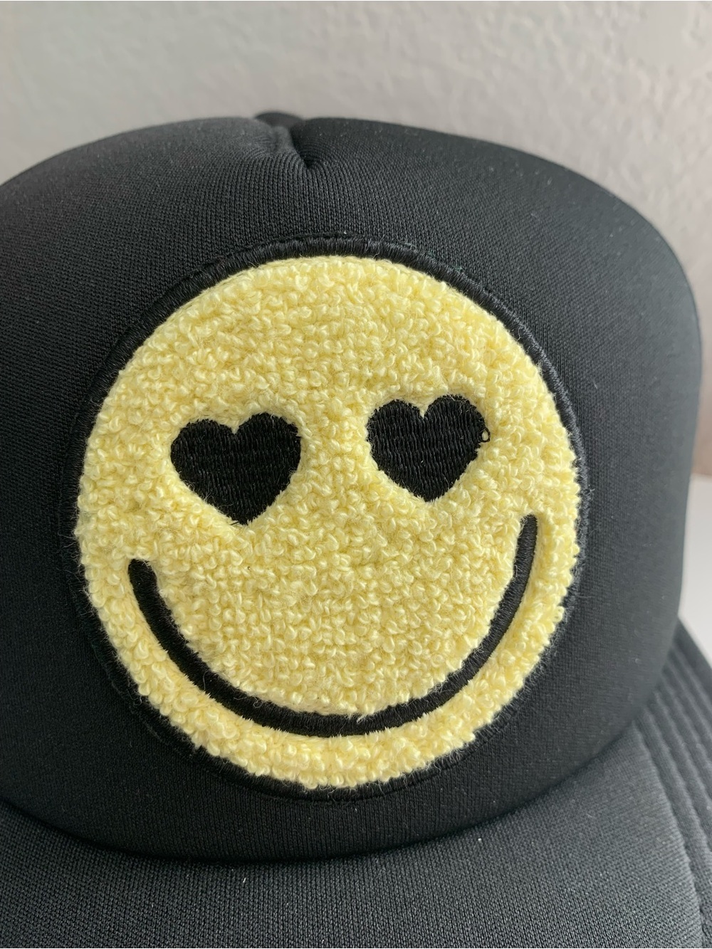 Black Trucker Hat with Yellow Fuzzy Smiley Face Patch with Heart-Eyes - Picture 2 of 6